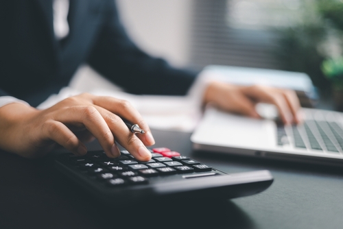 Workers Compensation Lawyer in Las Vegas Nevada Person typing on a calculator and a laptop