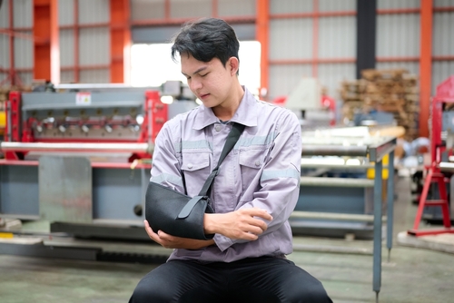 Man holding his arm in a sling from an accident