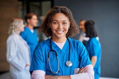 In Need of Workers Compensation Lawyer in Las Vegas Nevada Woman doctor wearing a stethoscope with other doctors behind her in the distant