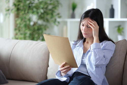 Worried Woman Reading Houston Insurance Denial Letter