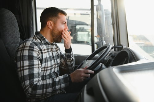 Tired Truck Driver Yawning Behind Wheel in Trenton