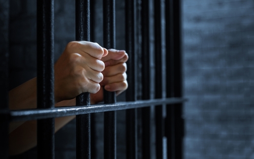 Hands Gripping Prison Bars After Felony Arrest Phoenix AZ