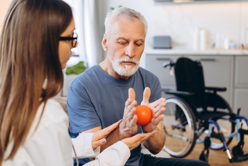 Vocational Rehabilitation Specialist Assisting Injured Worker Reno Nevada Man doing hand exercises with an orange ball as part of his rehab