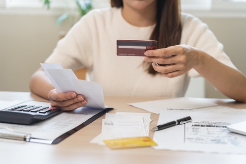 Stressed Woman Dealing With Credit Bureau Dispute Henderson Nevada Stressed woman reviewing bills and calculator at table with overdue payment documents