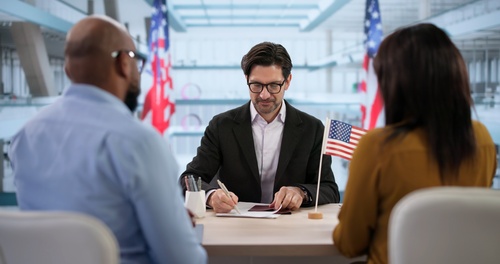 Family seated across desk from lawyer reviewing documents during office consultation