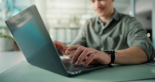 AI Child Exploitation Law Research Salt Lake City Utah Man typing on laptop at office desk during online research session