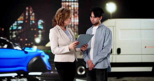 St. Louis Driver and Lawyer Discussing Missouri Insurance Claim Woman holding clipboard speaks with man beside damaged car and delivery truck