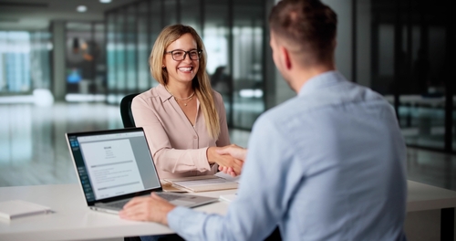 Rock Hill Child Support Attorney Client Consultation Professional meeting handshake across desk with laptop and documents in office