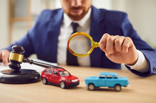 Albuquerque Car Accident Lawyer Reviewing Comparative Negligence Case Toy car beside attorney reviewing documents at desk during car accident case