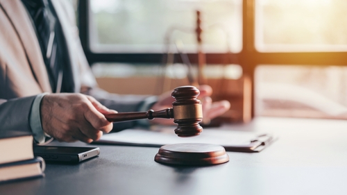 Salt Lake City Domestic Violence Defense Attorney Gavel Lawyer holding gavel beside legal documents on desk