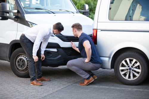 Philadelphia Delivery Company Car Accident Inspection Two men inspecting car bumper and headlight after vehicle damage assessment