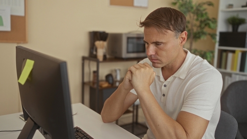 St. Louis Attorney Reviewing Missouri Wrongful Death Claim Deadline Man clasping hands beside computer monitor at office desk