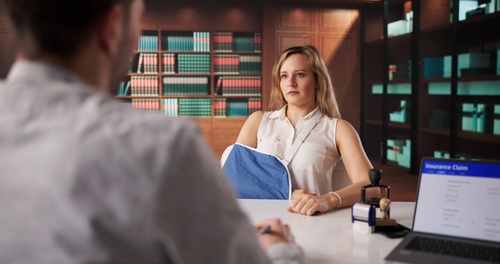 Attorney reviewing workers injury compensation documents with calculator on office desk