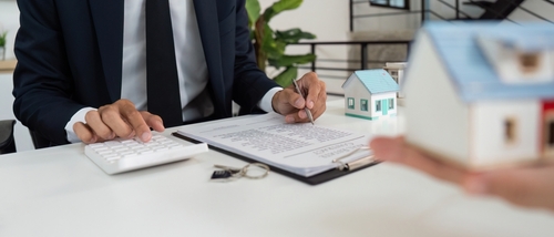 Mesa Arizona Small Estate Affidavit Attorney Consultation Professionals discussing documents beside house model and keys during real estate transaction
