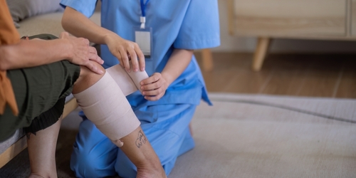 Nurse Bandaging Dog Bite Wound on Patient Leg Bend Oregon Nurse Bandaging Dog Bite Wound on Patient Leg Bend Oregon