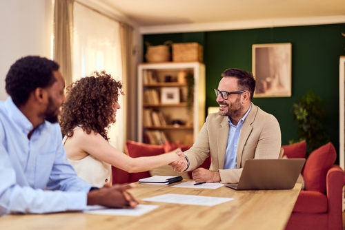 Houston Homeowners Meeting Insurance Claim Attorney Young couple meeting with professional agent at desk, reviewing documents together
