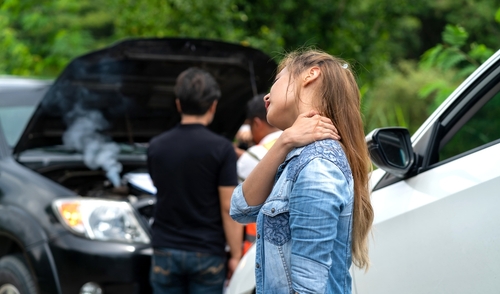 Woman With Neck Injury After Memphis Car Accident Woman seated in car clutching neck after apparent traffic collision