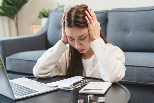 Stressed Person Facing Financial Crisis Before Chapter 13 Chicago Stressed man holding head beside calculator, bills, and bankruptcy notice