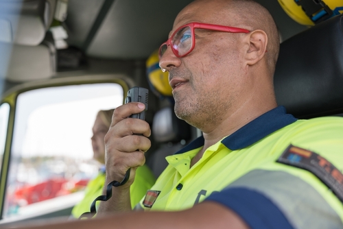 Paramedic Responding to Fatal Crash on Alabama Highway 24 Paramedic speaking into walkie-talkie beside ambulance during emergency response scene