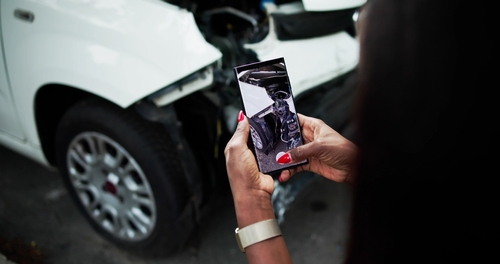 Photographing Truck Crash Damage After Aurora IL Accident person photographing damaged vehicle with smartphone after car accident