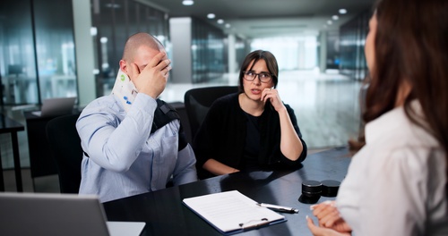 St. Louis Truck Accident Passenger Meeting Injury Lawyer injured man wearing neck brace meeting with attorneys across office desk