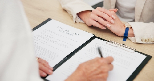 Signing Last Will and Testament With Santa Fe Trust Attorney attorney and client signing Last Will and Testament document on clipboard