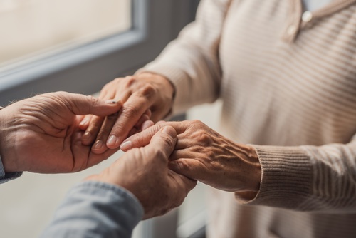 Elderly Couple Trust Planning New Mexico elderly couple holding hands gently near window in close-up view