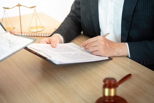 Miami Cruise Ship Attorney Reviewing Negligence Claim Documents lawyer in suit reviewing legal documents at desk with gavel and scales of justice