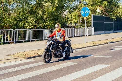 Motorcyclist Riding Through St. Louis Street Intersection helmeted motorcyclist riding black motorcycle through urban pedestrian crosswalk intersection