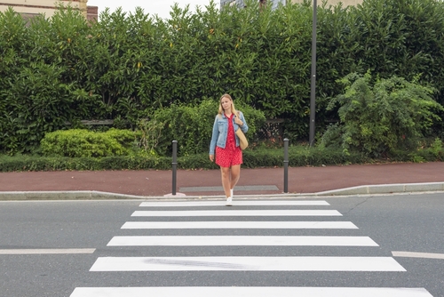 Pedestrian Crossing Crosswalk in Philadelphia Pennsylvania young woman carrying bag walking across marked pedestrian crosswalk on urban street