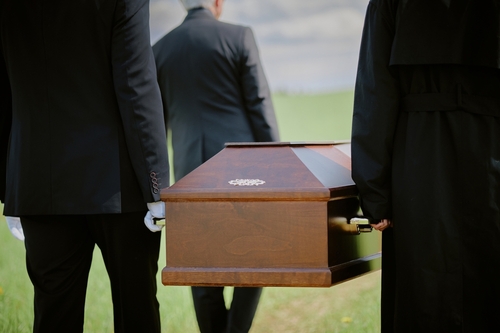 West Virginia Workplace Fatality Wrongful Death Funeral pallbearers in formal attire carrying wooden casket during outdoor funeral procession