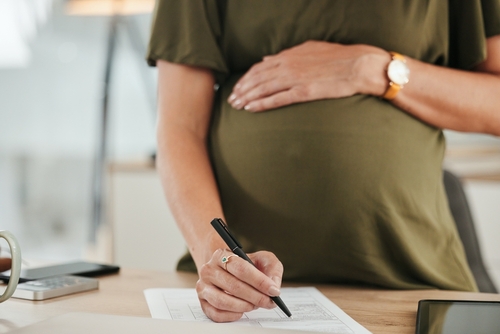 Pregnant Worker Signing Paid Prenatal Leave Documents New York