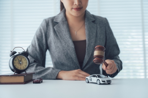 Schenectady Car Accident Lawyer Gavel Clock Legal Claim attorney holding gavel over model car and alarm clock on desk