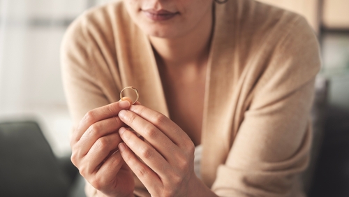 Woman Removing Wedding Ring Adultery Divorce Rock Hill SC woman holding wedding ring between fingers during divorce proceeding