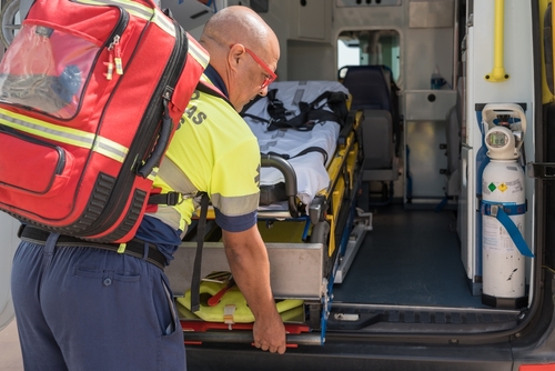 Paramedic Loading Stretcher Into Ambulance After Philadelphia Intersection Crash paramedic carrying medical backpack loading stretcher into open ambulance