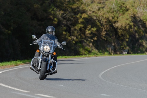 Motorcyclist Riding on Illinois Road Lane Splitting Laws helmeted rider on classic cruiser motorcycle navigating curved open road