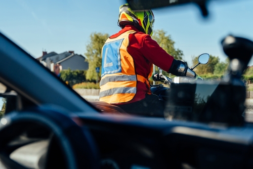 Roanoke Motorcycle Rider Seen From Car Fault Liability motorcycle learner rider wearing safety vest and helmet on road