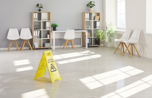 Yellow Wet Floor Caution Sign Florida Slip Fall Hazard Caution Wet Floor warning sign placed on office floor near chairs