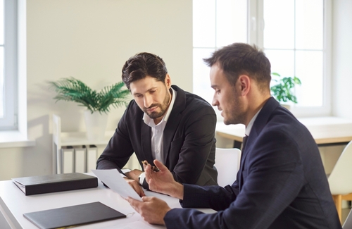 Tucson Criminal Defense Lawyer Reviewing Entrapment Case two attorneys in suits reviewing legal documents together at office desk