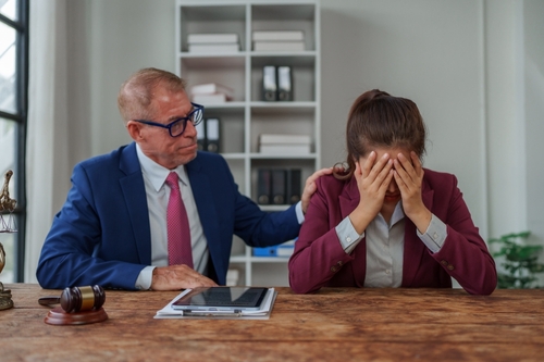 Dayton Wrongful Death Attorney Supporting Grieving Truck Accident Family attorney placing supportive hand on distressed client's shoulder in law office