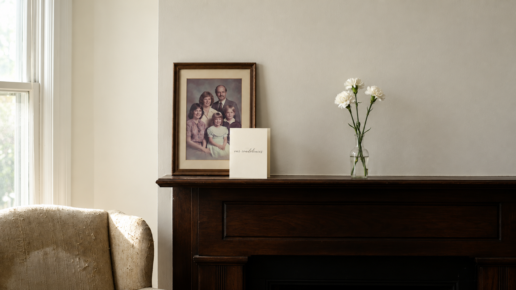 White condolence card reading our condolences beside framed family photo on mantel