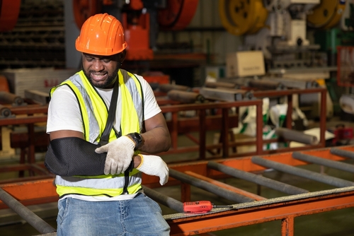 Construction worker holding his arm from an injury
