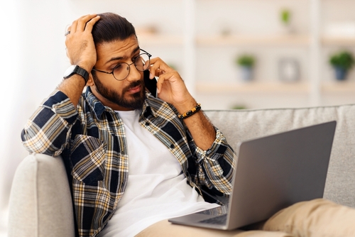 Man on the phone while on his laptop
